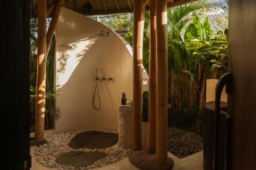a bathroom with a shower in a room with plants at Kaymana in Uluwatu