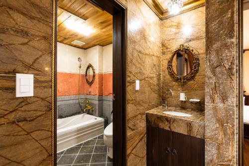 a bathroom with a tub and a toilet and a sink at Jeju Nine resort in Jeju