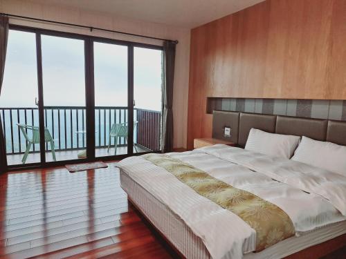 a bedroom with a large bed and a balcony at Shi Home 1639 in Zhushan