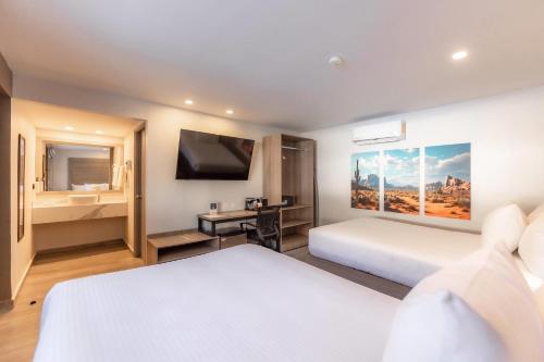 a hotel room with two beds and a television at Comfort Inn Hermosillo Pitic in Hermosillo