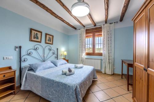 a bedroom with a bed with blue walls and a window at Casa Rural Cortijo Celdran in Vélez-Rubio