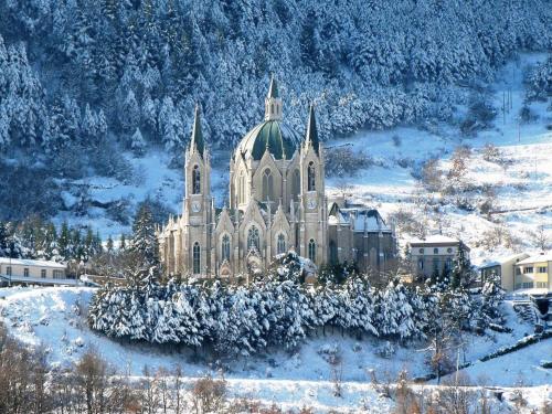 a large building with a green roof in the snow at La Fonte dell'Astore in Castelpetroso