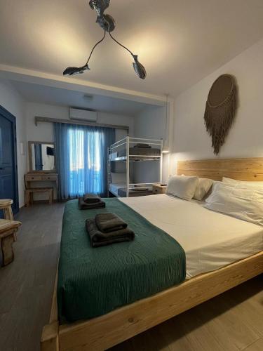 a bedroom with a large bed with green sheets at sun studios in Mikonos
