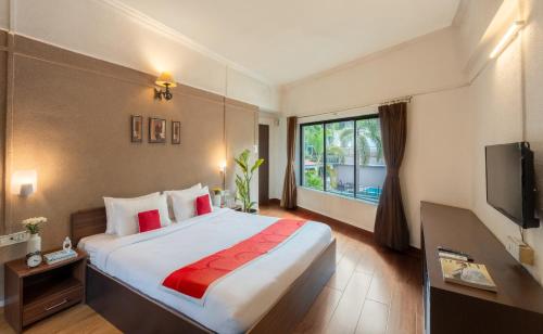 a hotel room with a large bed and a television at Velvet Resort Khandala in Khandāla