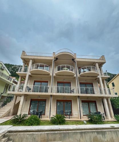 a large building with balconies and tables at Apartments Sofia in Kotor