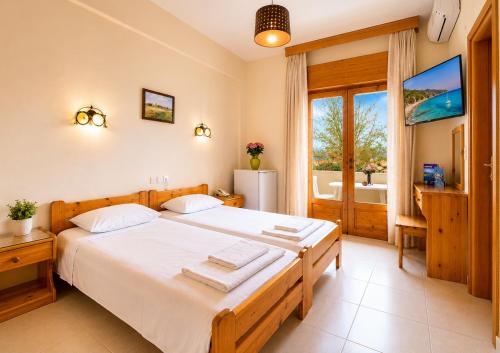 a bedroom with a large bed and a large window at Yannis Hotel in Krinídhes