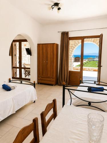 a bedroom with two beds and a view of the ocean at Avgerinos Village in Agiassos