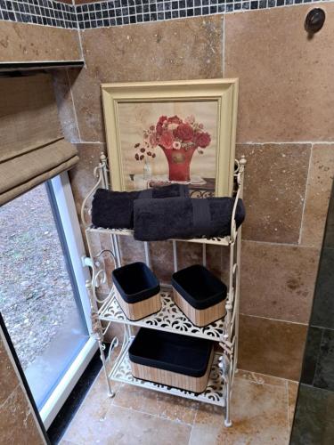 a towel rack with a vase on it next to a window at Le clos d'oli in Wamin