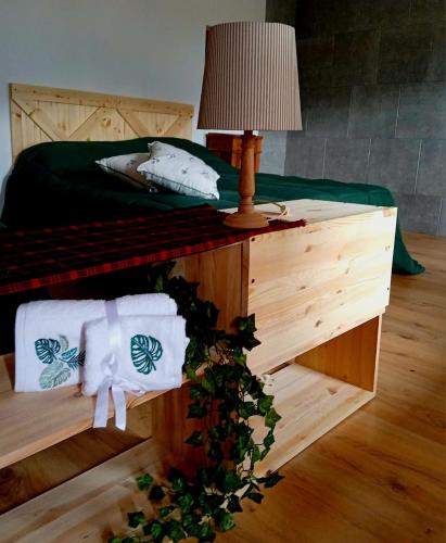 a bedroom with a bed and a table with a lamp at il Bucaneve in Norcen