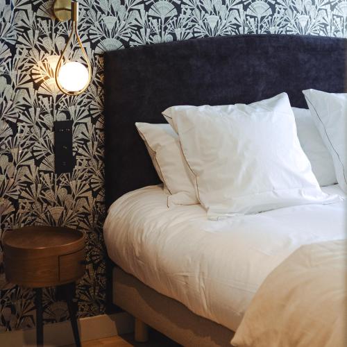 a bedroom with a bed with a black and white wallpaper at L'ODE A PIERRE - Chambres d'hôtes in Dax