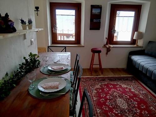 a living room with a table with plates and wine glasses at il Bucaneve in Norcen