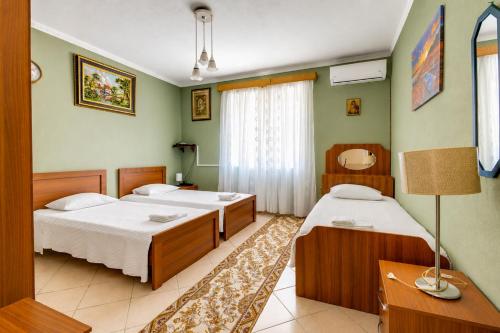 a bedroom with two beds and a table and a lamp at Swimming Pool - Valley View Home Drobonik in Drobonik