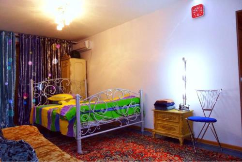 a bedroom with a bed and a table in a room at Квартира 89 in Bishkek