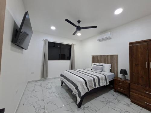 a bedroom with a bed and a ceiling fan at Lions Houses in Parrita