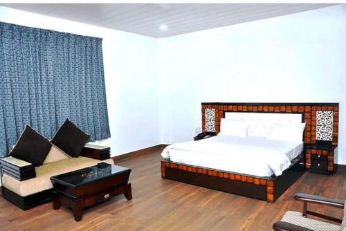 a bedroom with a bed and a couch at Hotel Aam Bagh & Jain Shikanji in Kot Pūtli