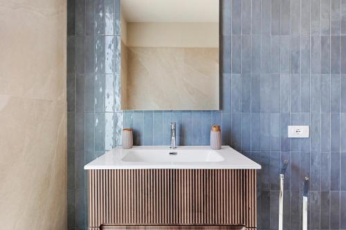 a bathroom with a sink and a mirror at Brezza Apartments in Santa Flavia