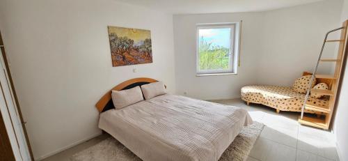 a bedroom with a bed and a chair and a window at Ferienhaus Panoramablick Altfalter in Schwarzach bei Nabburg