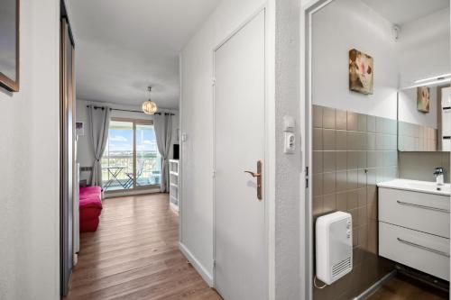 a kitchen with a sink and a door to a room at T2 dans résidence arborée in Six-Fours-les-Plages