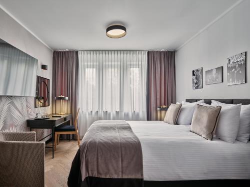 a hotel room with a large bed and a desk at Dethloff Art Residence in Warsaw