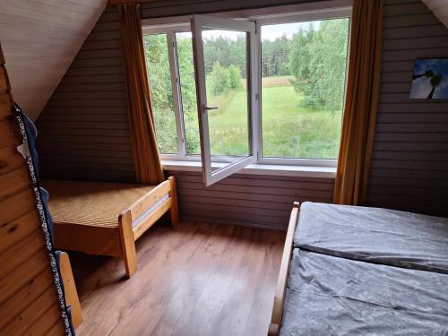a small room with a bed and a window at Palmas in Jūrkalne