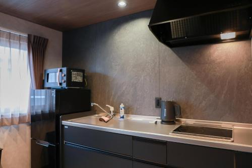 a kitchen with a sink and a refrigerator at INNEST Hakata in Fukuoka