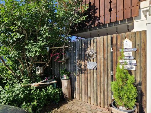 a wooden fence with plants and signs on it at Chalet Gotthelf Gartenstudio, Ferien mit Hund in Adelboden