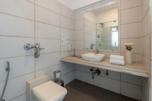 a bathroom with a sink and a toilet and a mirror at Velvet Resort Khandala in Khandāla