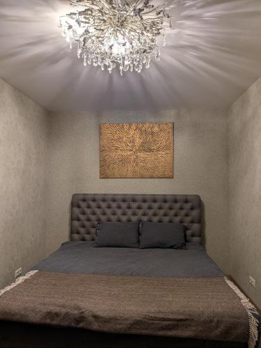 a bedroom with a large bed with a chandelier at Zaķēni in Āboliņi