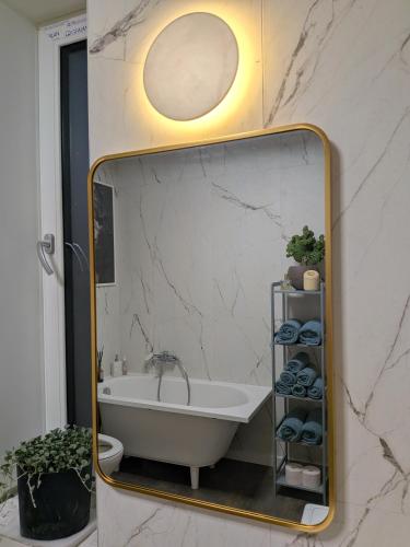a mirror in a bathroom with a bath tub at Zaķēni in Āboliņi