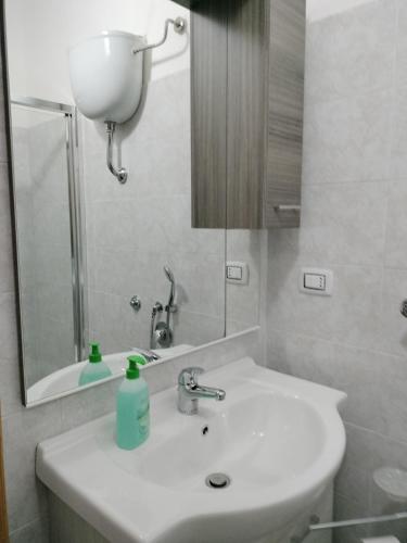 a bathroom with a white sink and a mirror at beb san Nicola in Ortueri