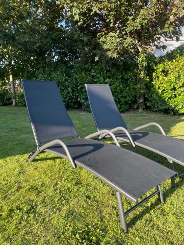 two lounge chairs sitting on the grass in a yard at Ferienhaus 'Seeblick 39' in Glücksburg