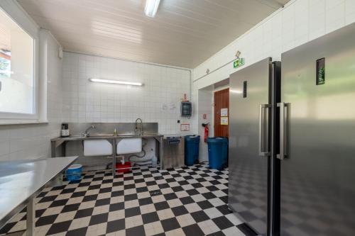 a kitchen with a black and white checkered floor at Les Sources - 30 personnes in Bussang