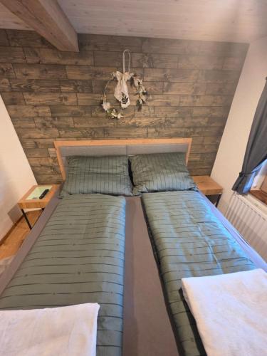 a large bed in a room with wooden walls at Ferienwohnung Loifried in Abtenau