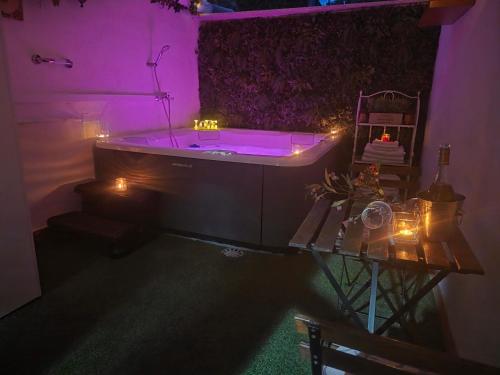 a purple bathroom with a tub and a table with lights at El Secreto de Boada Spa privado & Restaurante Adults Only in Villamiel