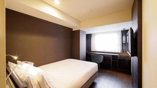 a hotel room with a bed and a desk at HOTEL AMANEK Osaka Namba in Osaka