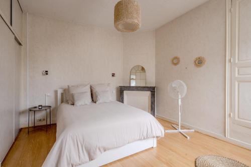 a bedroom with a white bed and a fireplace at La Ferté - Centre-ville - Petfriendly in La Ferté-Bernard