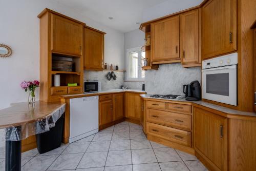 a kitchen with wooden cabinets and white appliances at La Ferté - Centre-ville - Petfriendly in La Ferté-Bernard
