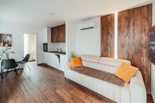 a living room with a white couch with orange pillows at Modern Seaside House in Pakoštane