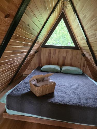 a bed in a wooden room with a window at Casuța din Colți in Colţi