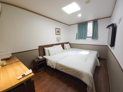 a bedroom with a large bed and a desk at 글로벌인 동대문 시티데이즈 인 호텔 in Seoul