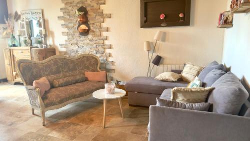 a living room with a couch and a chair at La Petite Maison - 4 voyageurs in Voudenay-lʼEglise