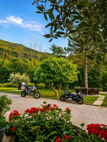two motorcycles parked on a road near some flowers at Pri Martinovih in Deskle