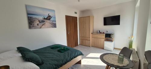 a bedroom with a bed and a living room at Karmelowy Zakątek in Darłowo