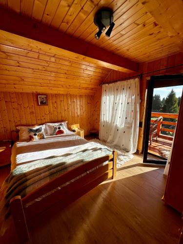 a bedroom with a bed in a wooden cabin at Cabana Apuseni N&D in Mărişel
