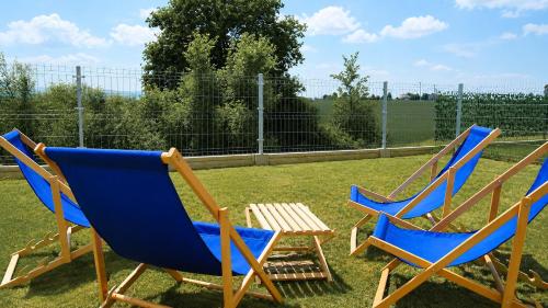 two blue chairs and a table in a yard at Serce Kotliny Kłodzkiej - Apartament 54m2 - 3 pokoje, balkon, ogródek in Kłodzko