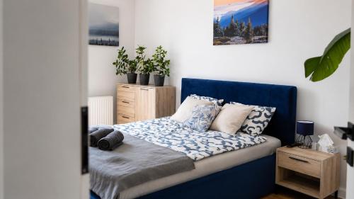 a bedroom with a blue bed with pillows on it at Serce Kotliny Kłodzkiej - Apartament 54m2 - 3 pokoje, balkon, ogródek in Kłodzko