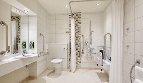 a bathroom with a toilet and a sink and a shower at Wirral Park Hotel in Greasby