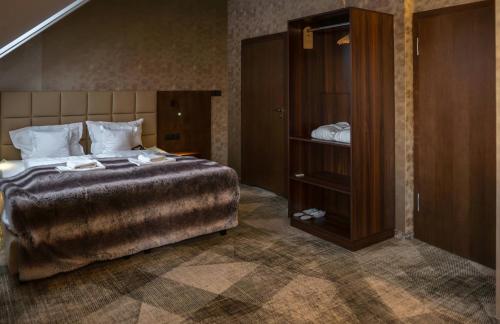 a bedroom with a large bed and a wooden cabinet at Osada Seidorf in Karpacz