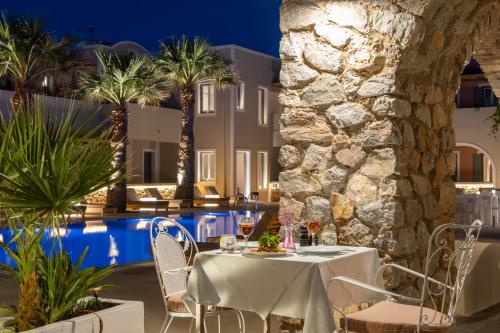 a restaurant with a table and chairs next to a pool at Rose Bay Hotel in Kamari