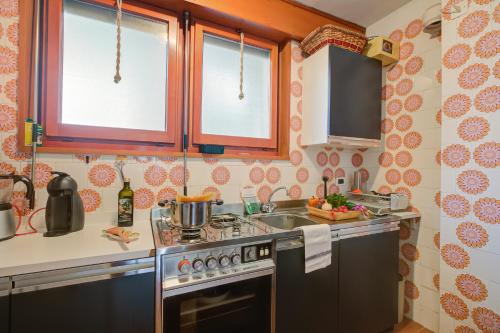 a kitchen with a stove and a sink at Lo Stambecco - Duplex for 8 people - Happy Rentals in Bardonecchia